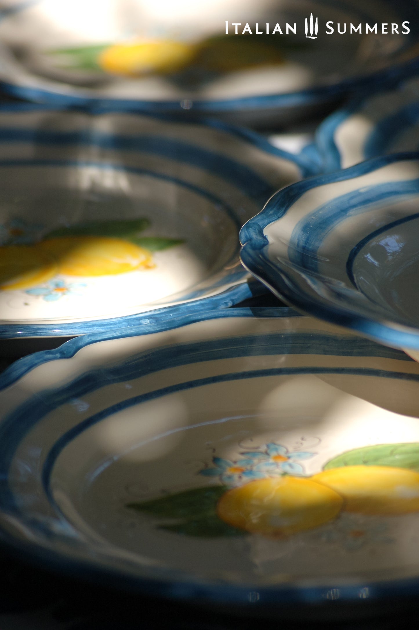 A custom made Italian maiolica ceramic dinner plate decorated with bright Sorrento Lemons and light blue stripes around the scalloped edge and in the  inside of the plate framing the lemons. 