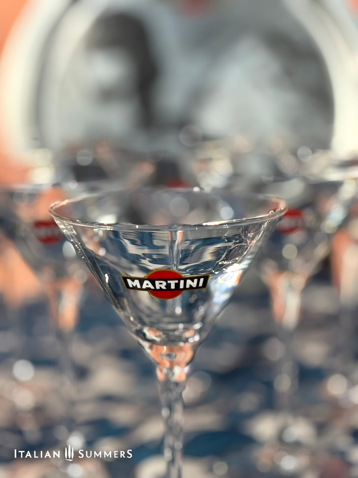 Close-up of a Martini glass with the brand logo, blurred background