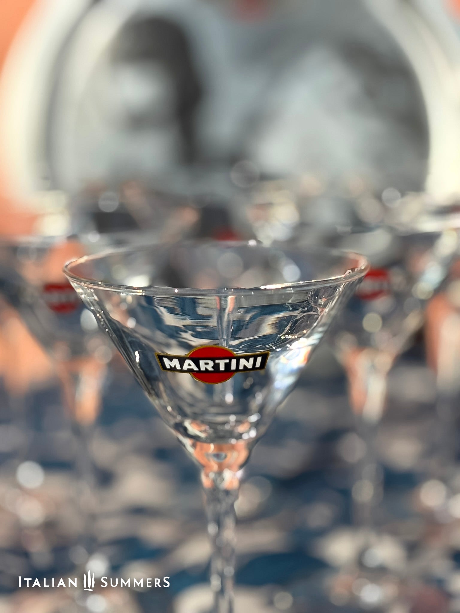 Close-up of a Martini glass with the brand logo, blurred background