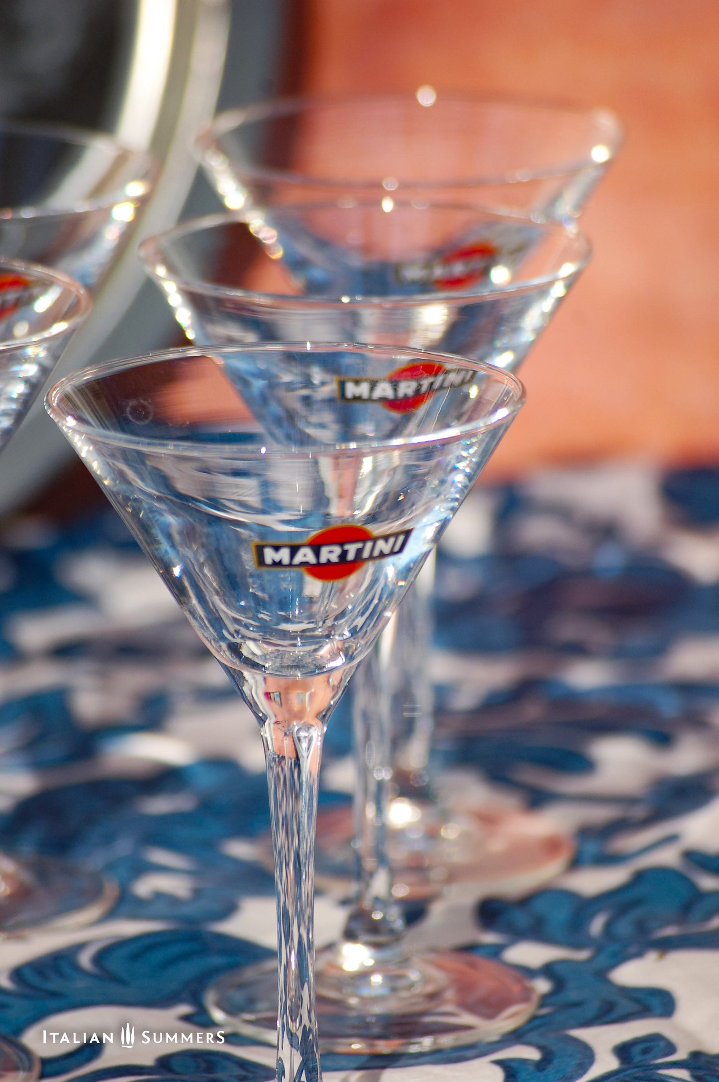 Martini glasses on a patterned tablecloth with a blurred background