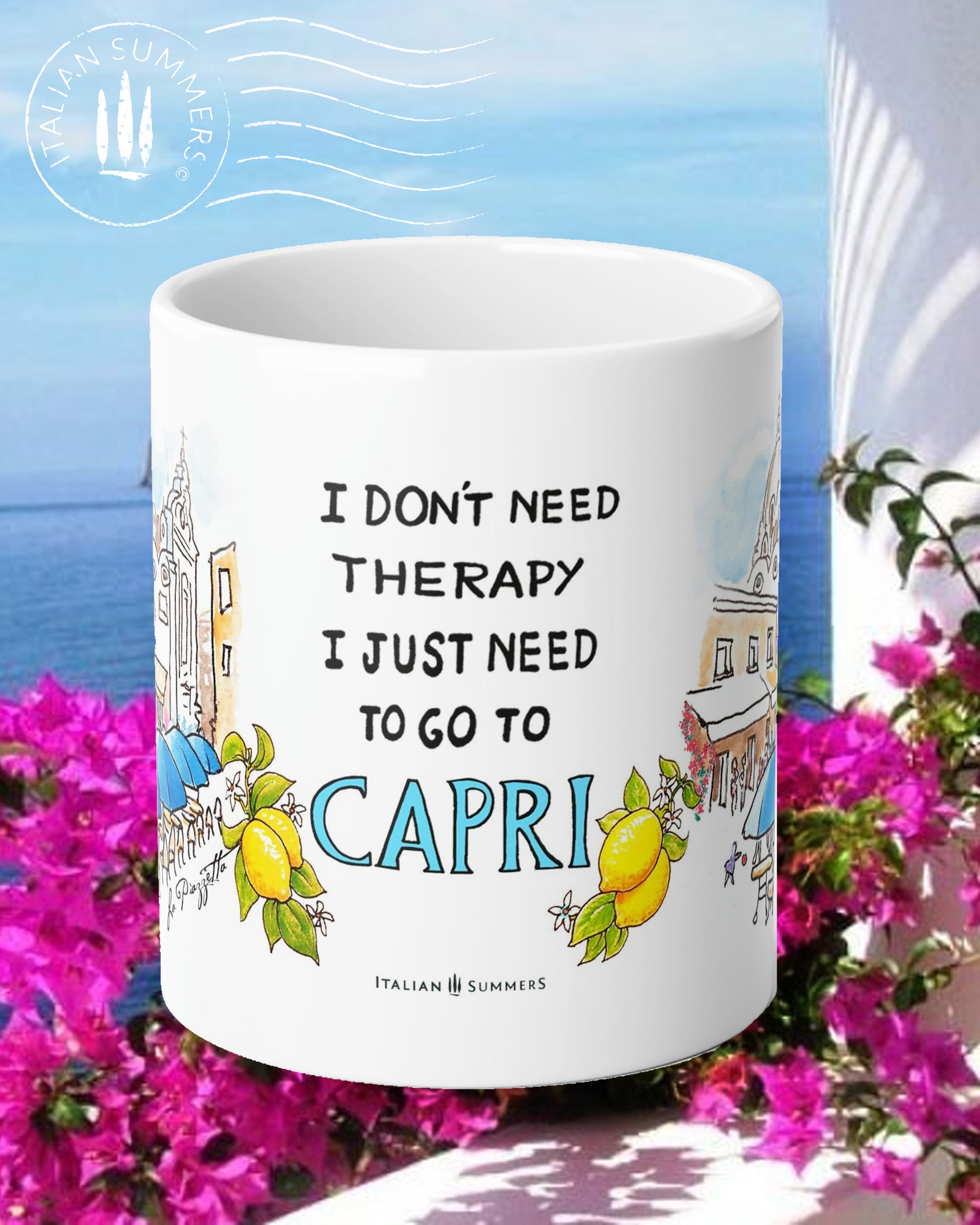 Italy-inspired white ceramic mug with blue colored handle and interior. Printed with a drawing of Capri's Piazzetta  with blue cafe Umbrellas and a crowd of shoppers strolling. The quote: I don't need therapy I just need to go to Capri is present . The word Italy is in blue Capital letters and flanked by bunches of Sorrento lemons with flowers. Made by Italian Summers