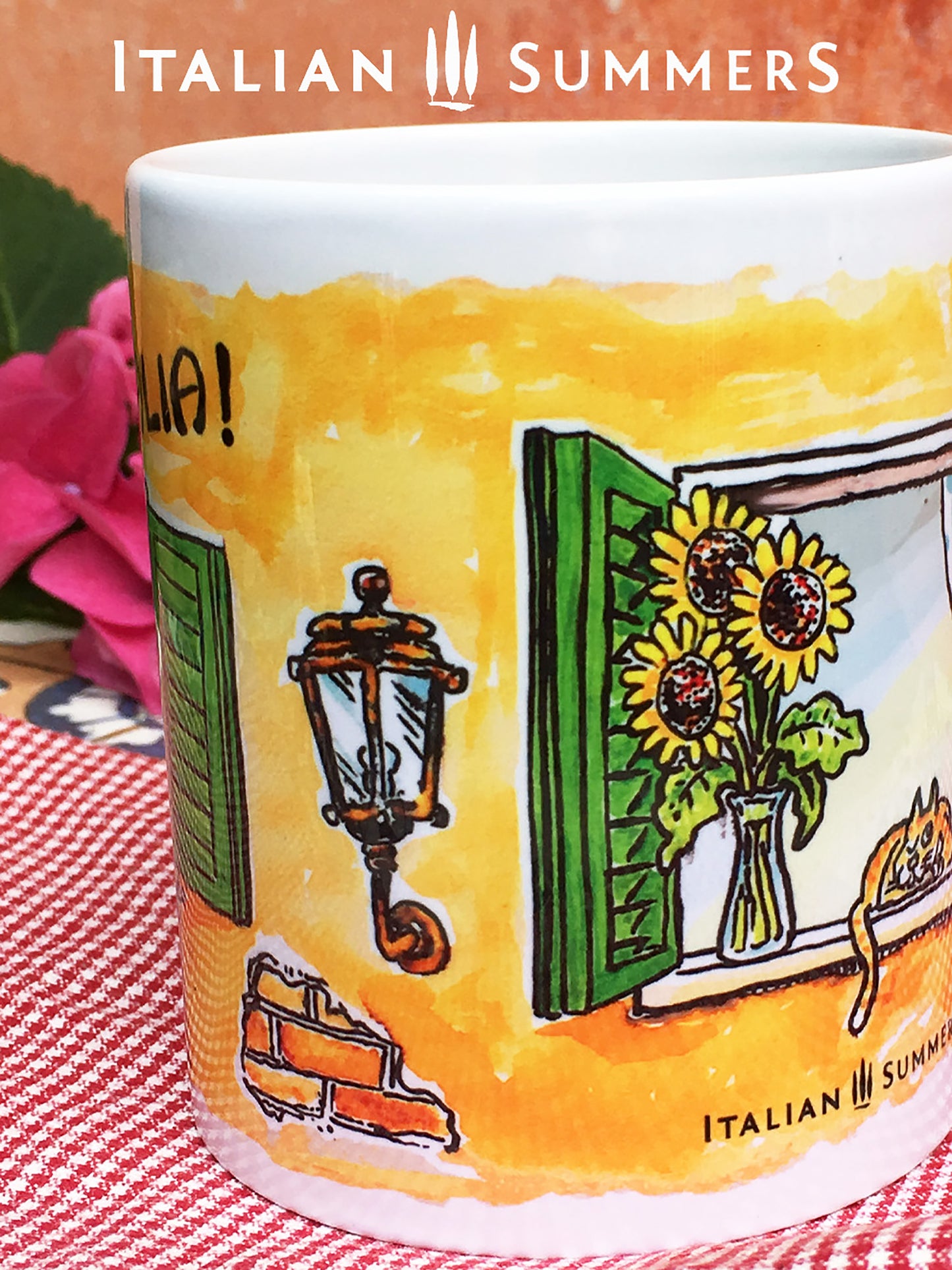 Italy inspired mug by sketches of an open Italian window. The window has green shutter, on the lower part of the windows hangs laundry in the color of the Italian flag. In the window sill ther is a red coffee mug and an Italian coffee poet, la moka. The Italian window is surrounded by a terracotta wall. Above the window there is written 'Buongiorno Italia' in black handwriting. Made by Italian Summers