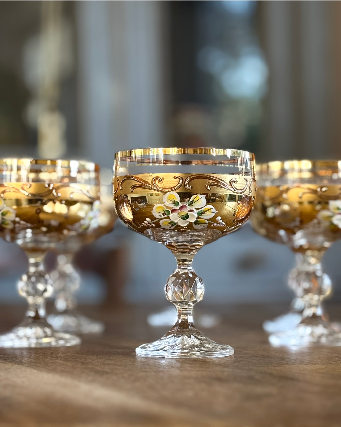 Decorative glass goblets with gold accents on a wooden surface