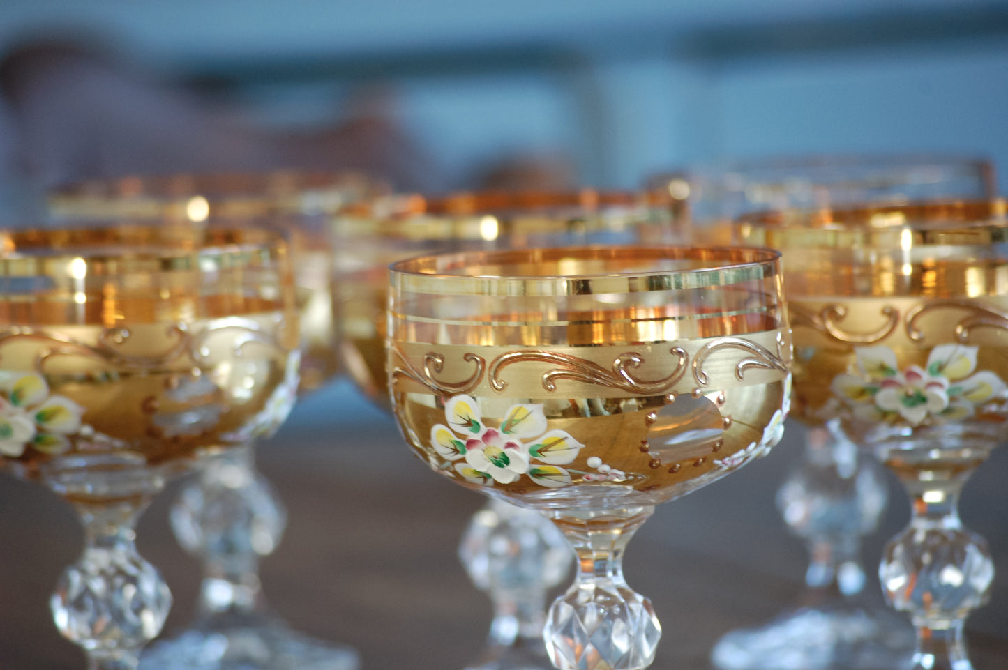 Decorative Murano glass goblets with floral patterns on gold surfaces