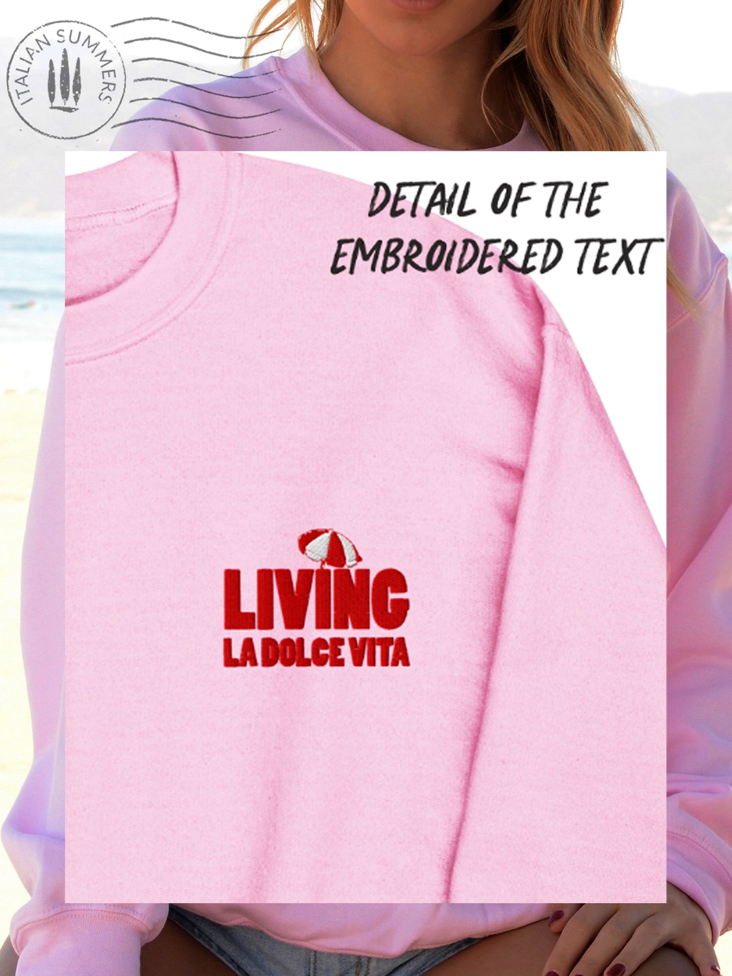  Soft and comfortable Italy-inspired  pink sweatshirt is embroidered in the front with the text 'Living la dolce Vita' in red bold letters and a small red and white beach umbrella on top. It features a large full-size print in the back with the same text and the same red and white beach umbrella. 