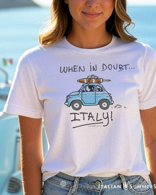 A woman wearing a tee with a cute blue vintage FIAT 500 rushing towards the sea with  a doggie in the back seat and a beach umbrella on the roof-rack.  Made by Italian Summers