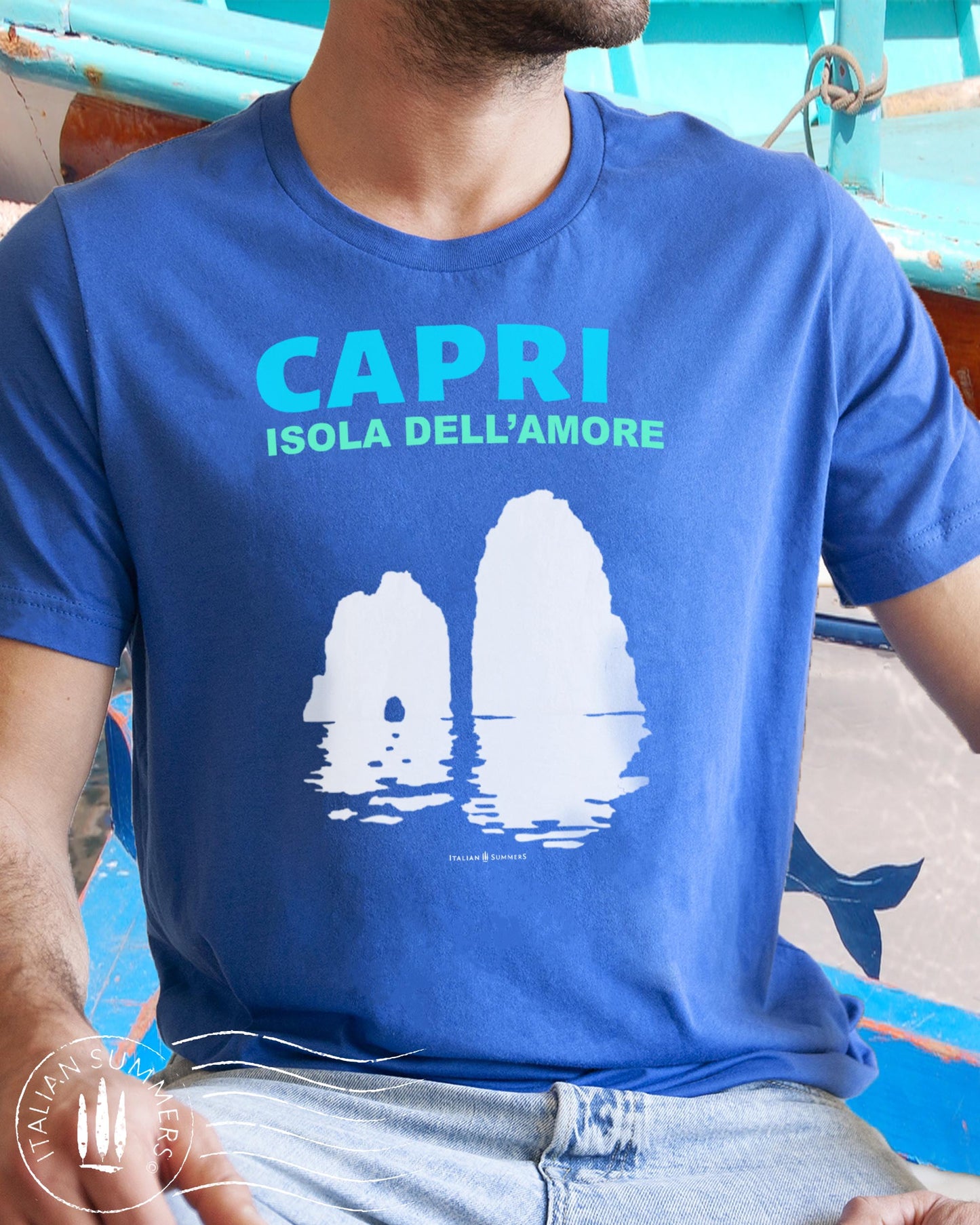 Italy inspired garment dyed T shirt with the aqua and white text: CAPRI, Isola dell'Amore (Capri, Iland of Love) with the silhouette  of the famous Faraglioni and their reflection umpon the waters of the Mediterranean Sea. Made by Italian Summers