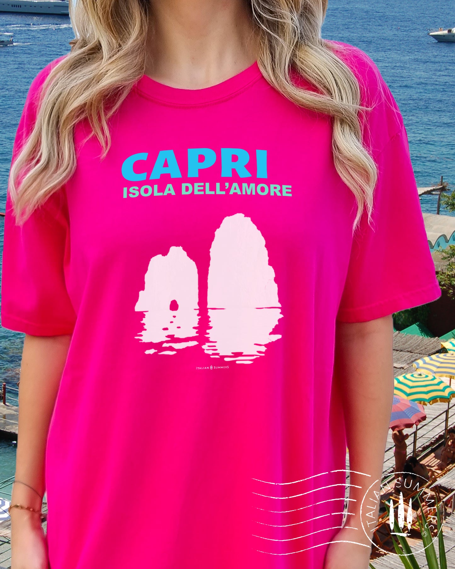 Italy inspired garment dyed T shirt with the aqua and white text: CAPRI, Isola dell'Amore (Capri, Iland of Love) with the silhouette of the famous Faraglioni and their reflection umpon the waters of the Mediterranean Sea. Made by Italian Summers
