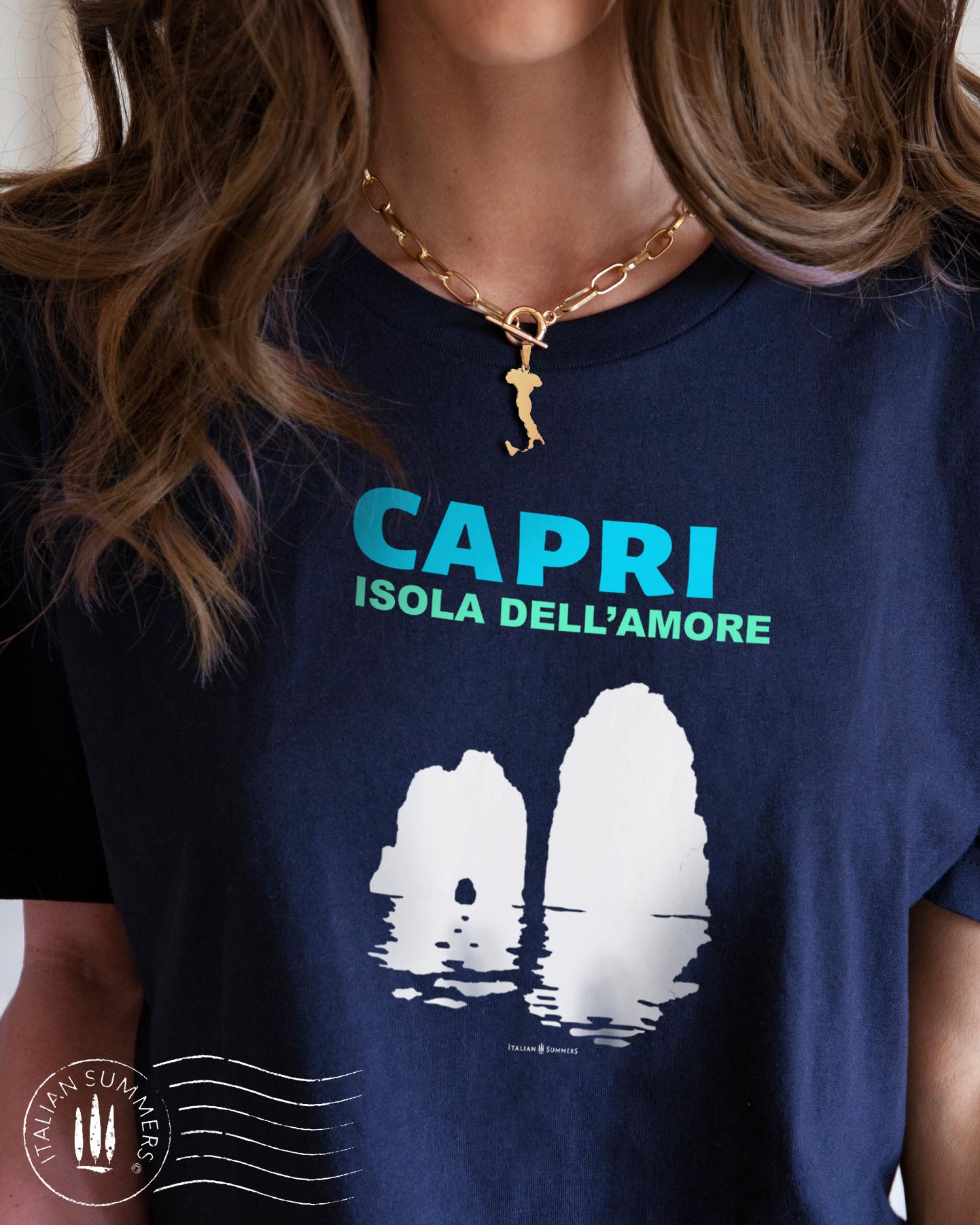 Italy inspired garment dyed T shirt with the aqua and white text: CAPRI, Isola dell'Amore (Capri, Iland of Love) with the silhouette of the famous Faraglioni and their reflection umpon the waters of the Mediterranean Sea. Made by Italian Summers