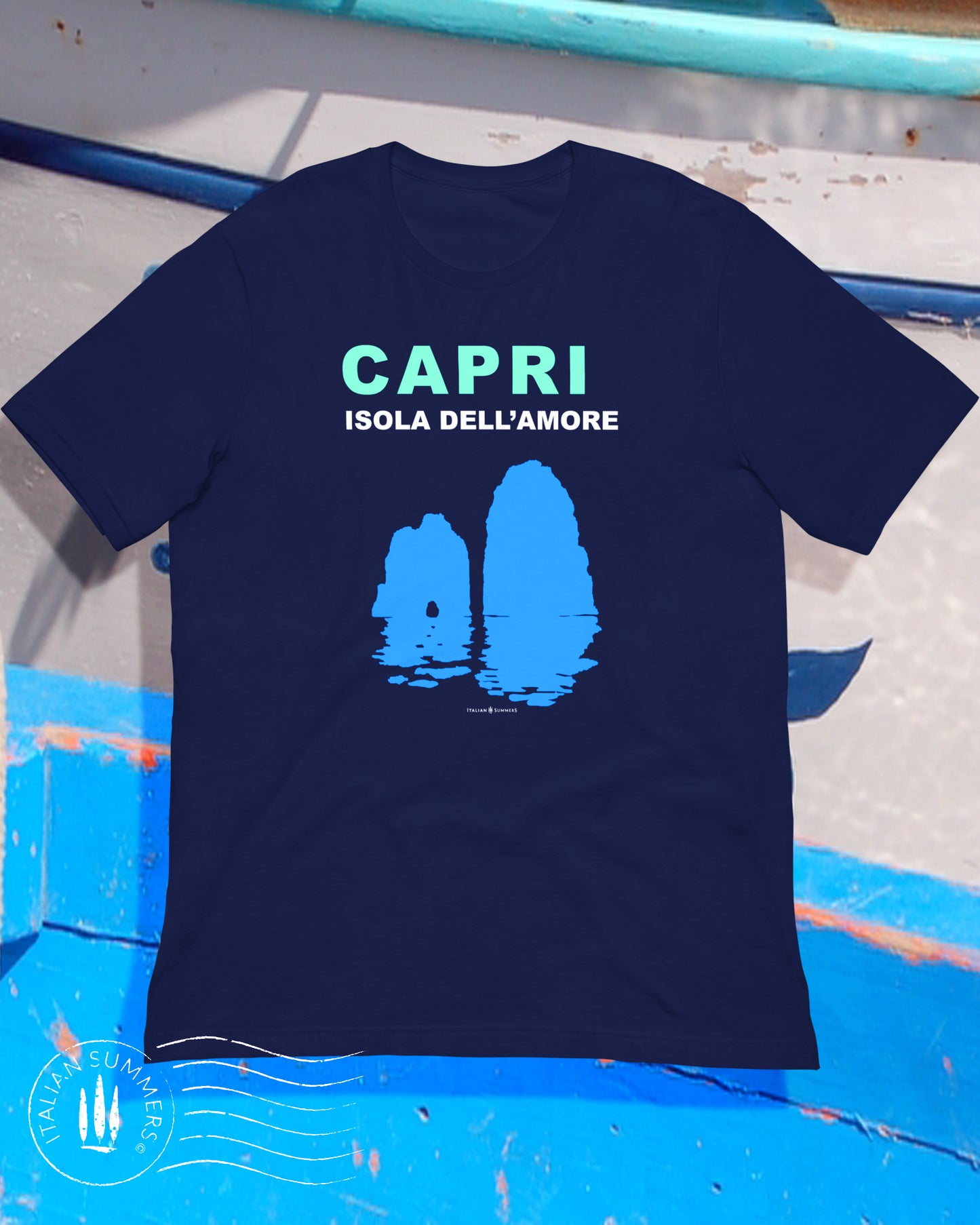 Italy inspired garment dyed T shirt with the aqua and white text: CAPRI, Isola dell'Amore (Capri, Iland of Love) with the silhouette  of the famous Faraglioni and their reflection umpon the waters of the Mediterranean Sea. Made by Italian Summers