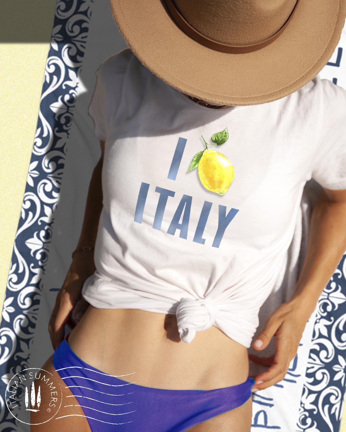 Italy Inspired white cotton unisex T shirt with the watercolored blue text : I Love Italy" where the word Love is symbolized by aan Amalfi Coast lemon instead of a red heart. Made by Italian Summers
