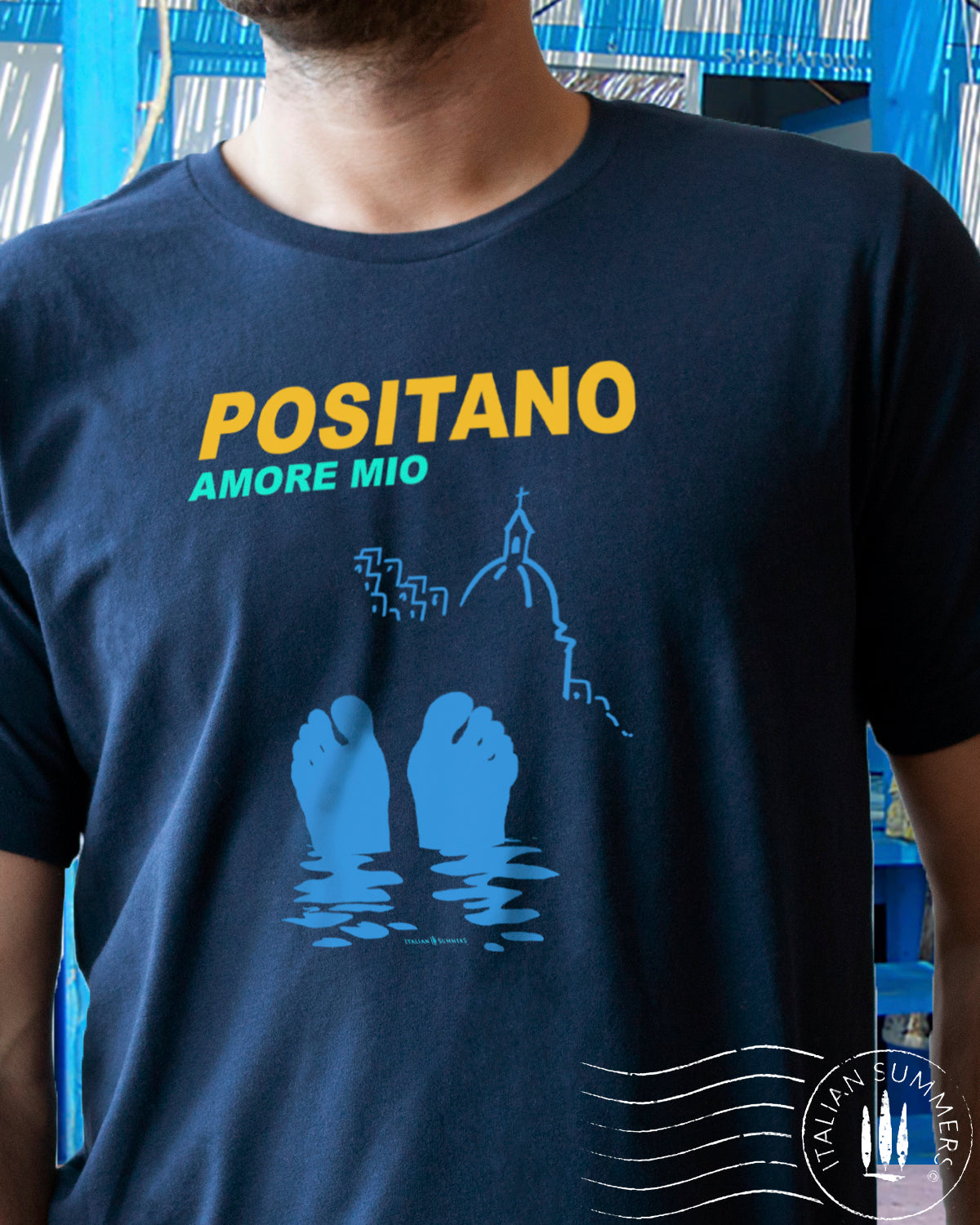 Italy inspired garment dyed T shirt with the text: POSITANO Amore Mio (Positano, my love) with a stylized view of the seaside town and the silhouette of two feet sticking out of the waters of the Mediterranean Sea. Made by Italian Summers