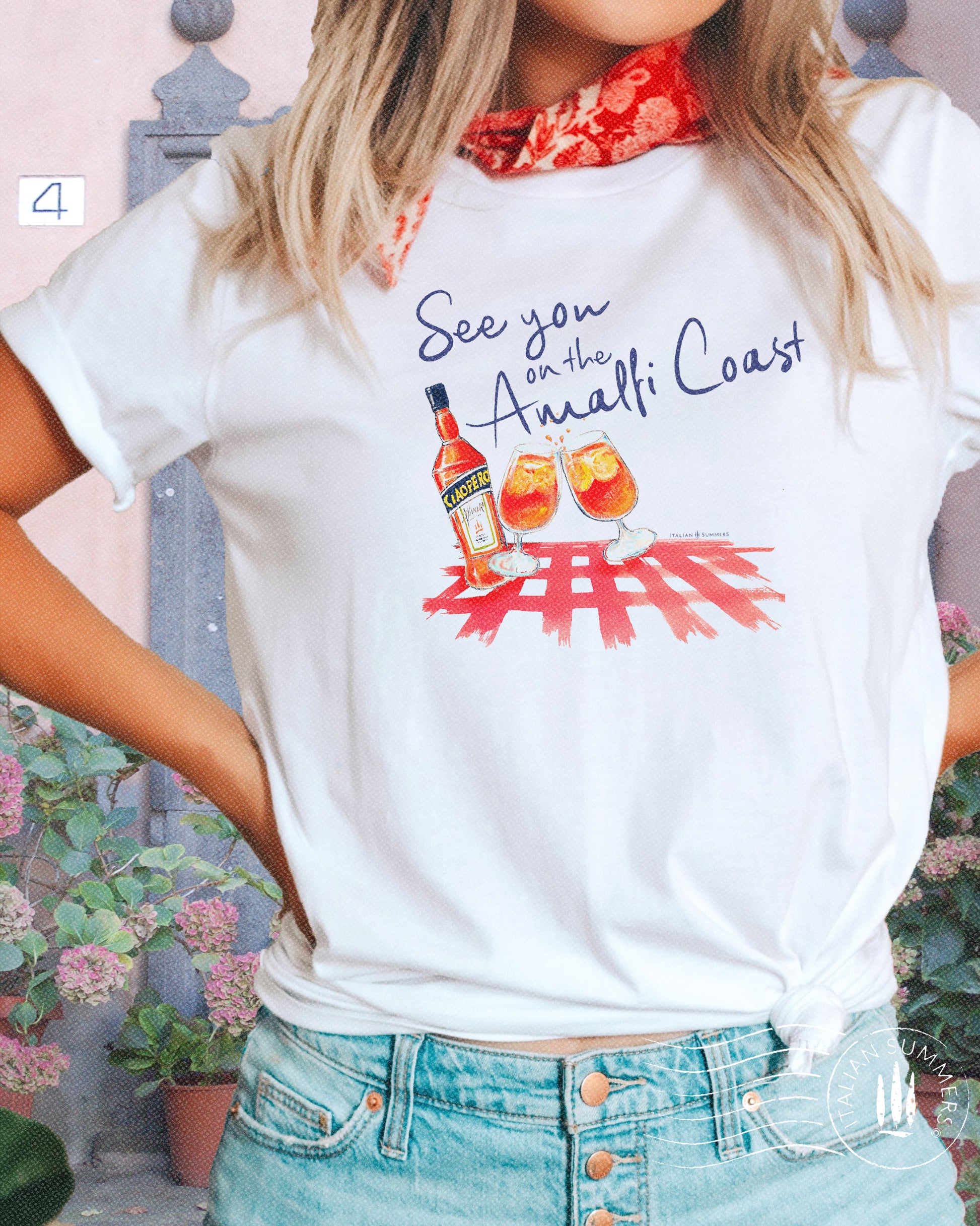 Italy inspired white t-shirt with the text See you on the Amalfi Coast in navy blue and a sketch in water color with an Aperol bottle and 2 glassis filled with Aperol Spritz on a bright red table cloth.