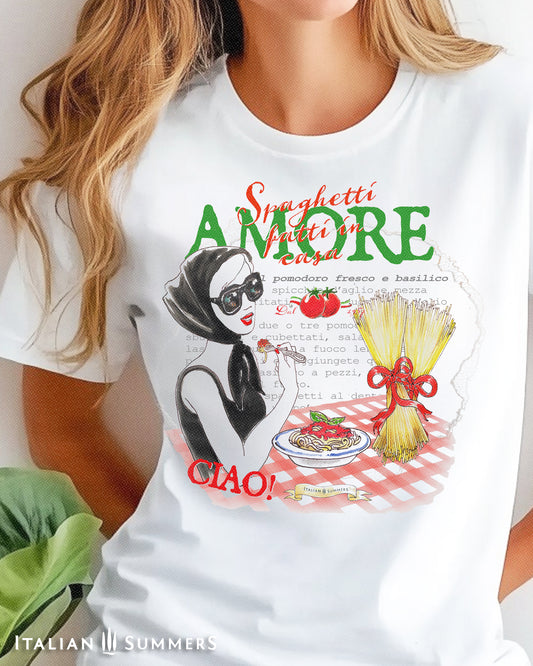 A woman wearing a white T shirt with drawing of a lady eating spaghetti while wearing a fashionable pair of glasses and the text " Spaghetti fatti in Casa- Amore" also features a recipe for 'spaghetti al pomodoro e basilico' text in the backround.