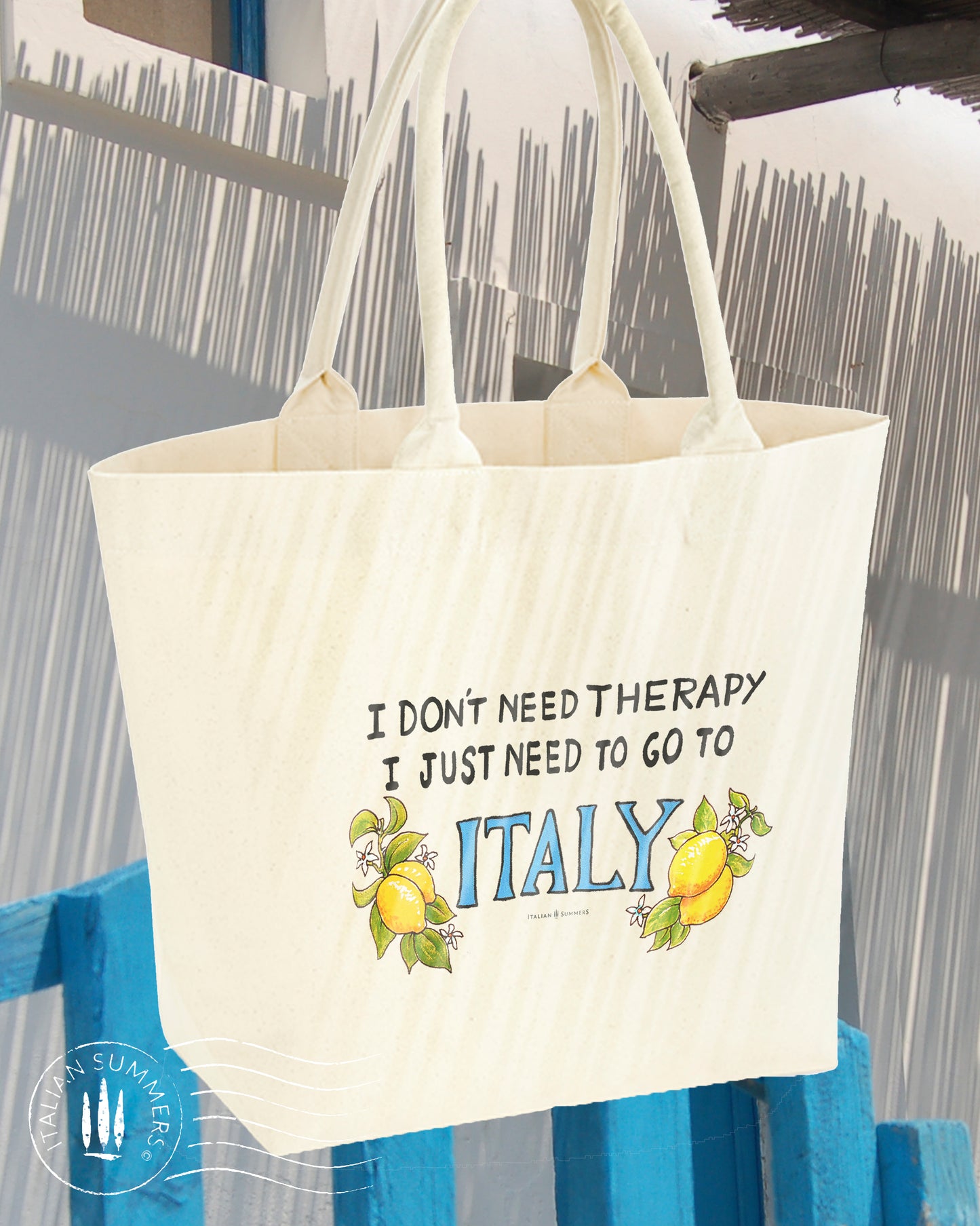 Tote bag with the quote " I don't need therapy, I just need to go to Italy " .The quote is flanked by Amalfi lemons with flowers. Designed and sold by Italian Summers