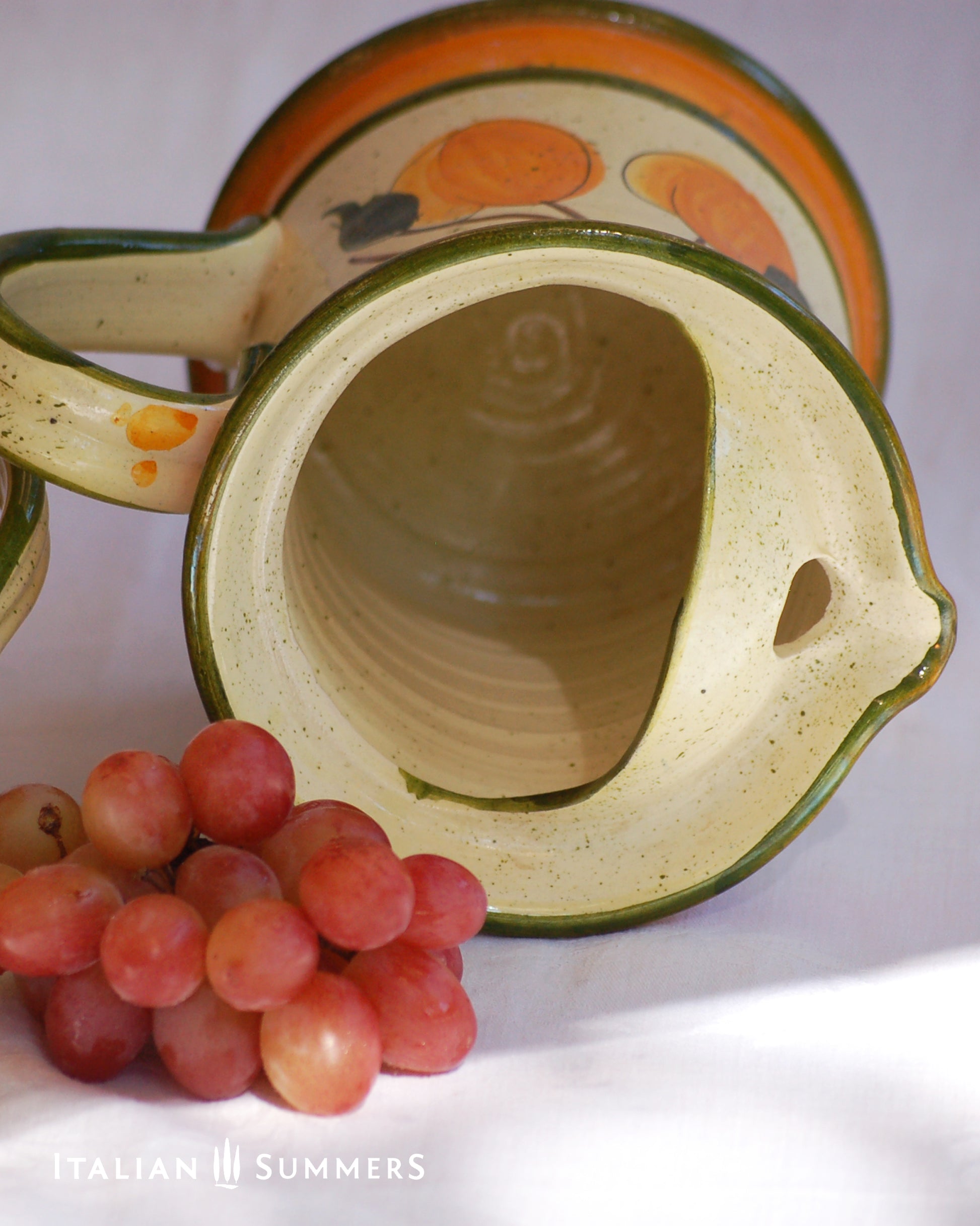 Ceramic pitcher with fruit design and grapes on a white background, featuring 'Italian Summers' branding.