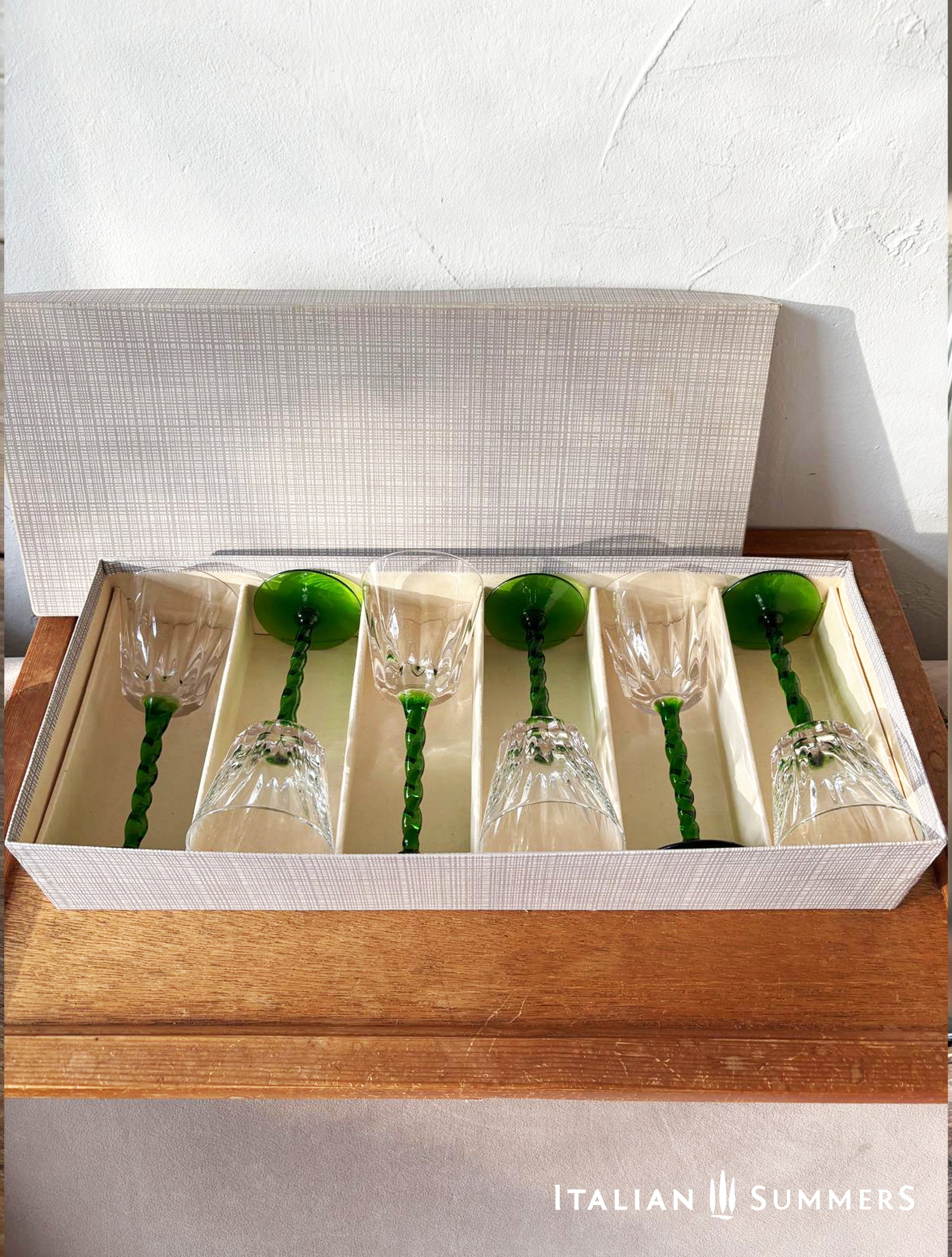 Set of six glass goblets with green stems in a box on a wooden surface, branded 'Italian Summers'.