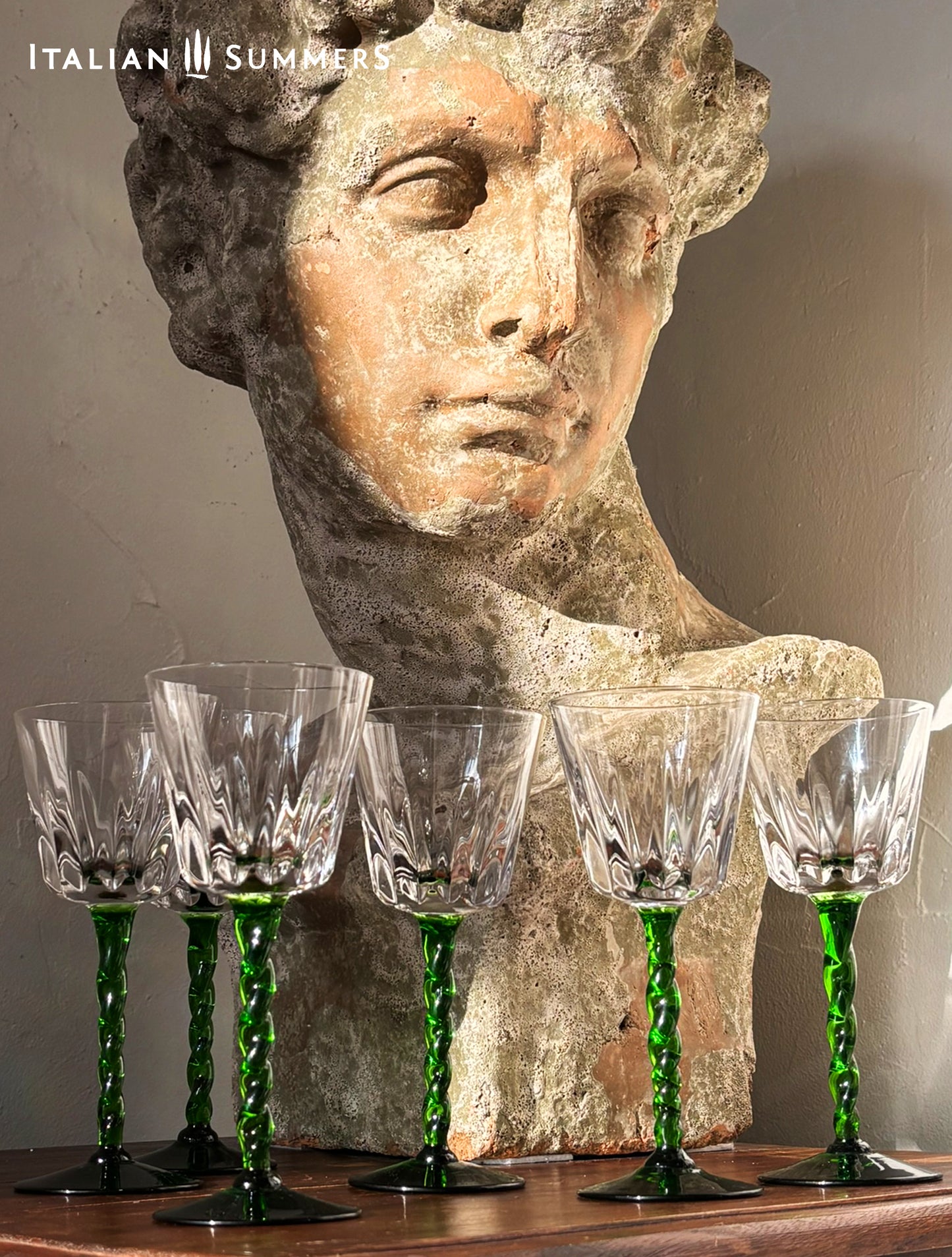 Vintage-style bust with crystal glasses on a wooden surface