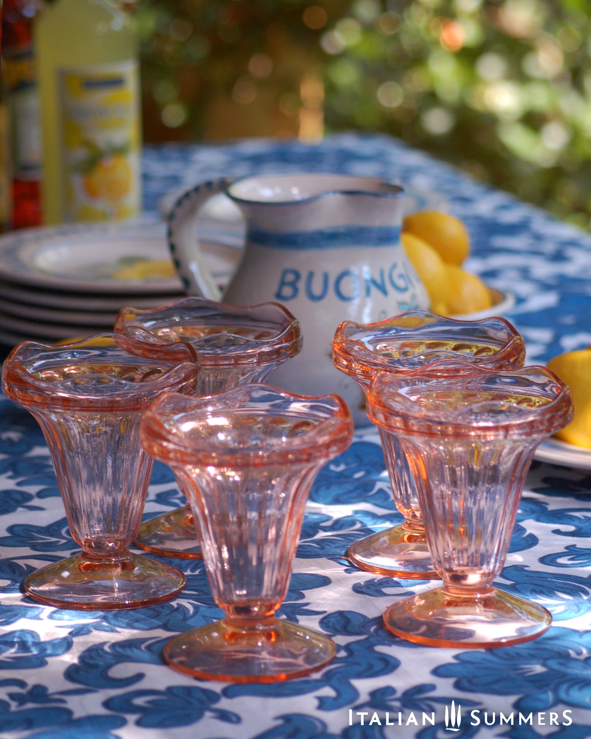 Set of vintage French pink glass dessert coupes  on a blue and white floral patterned tablecloth