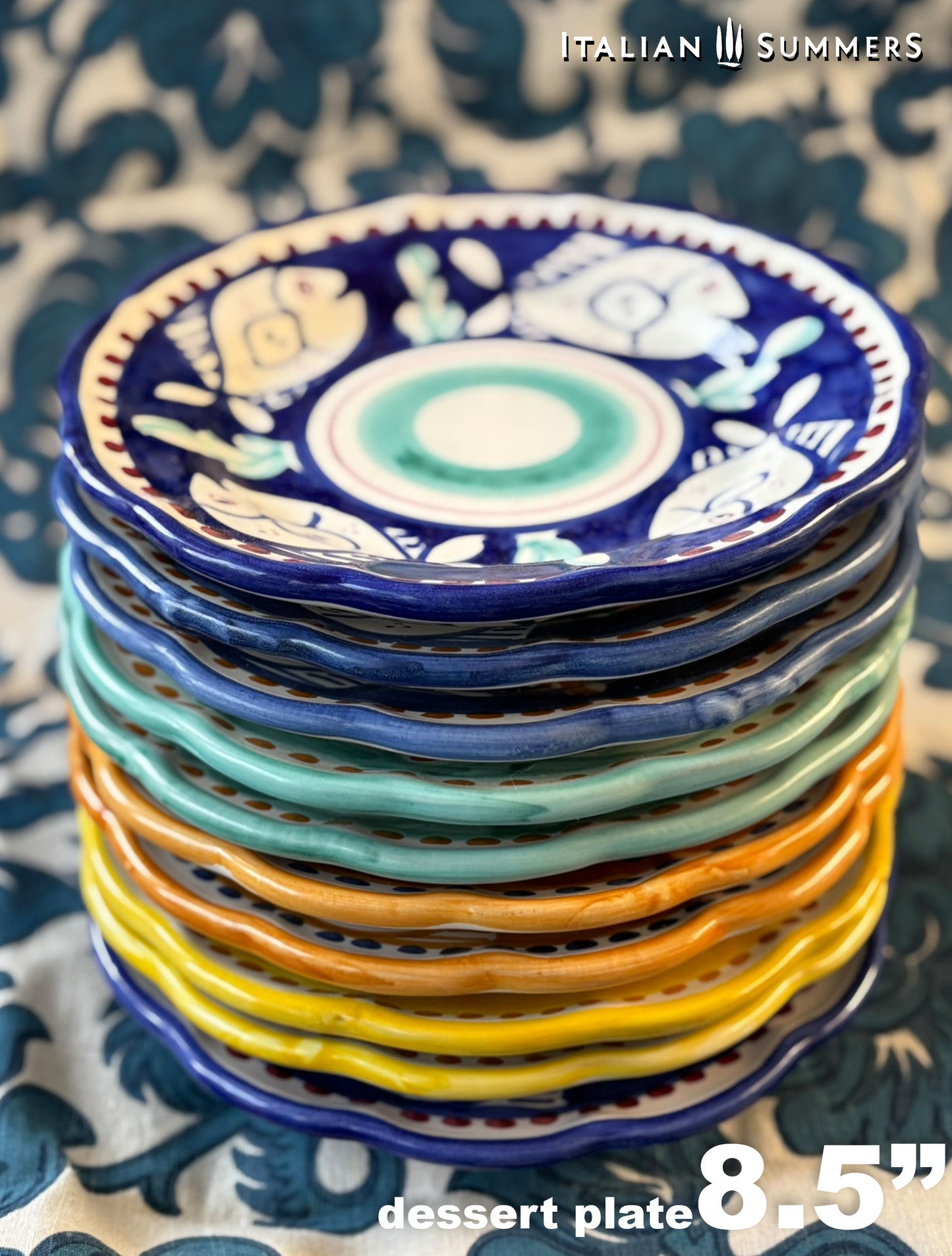 A Pile of multi-Coloredl hand-painted Vietri Pasta Plates with fish theme decorations from the Amalfi Coast on a blue and white tablecloth