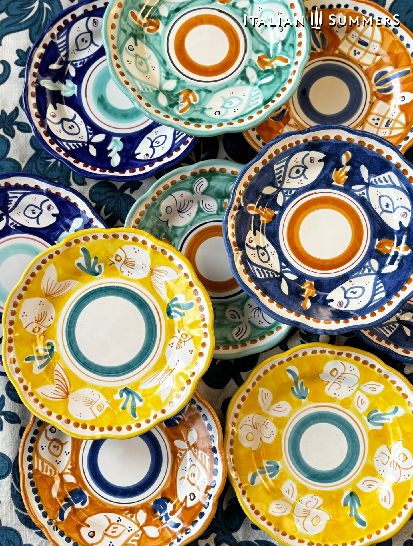  A group of Colorful hand-painted Vietri Pasta Plates with fish theme decorations from the Amalfi Coast on a blue and white tablecloth