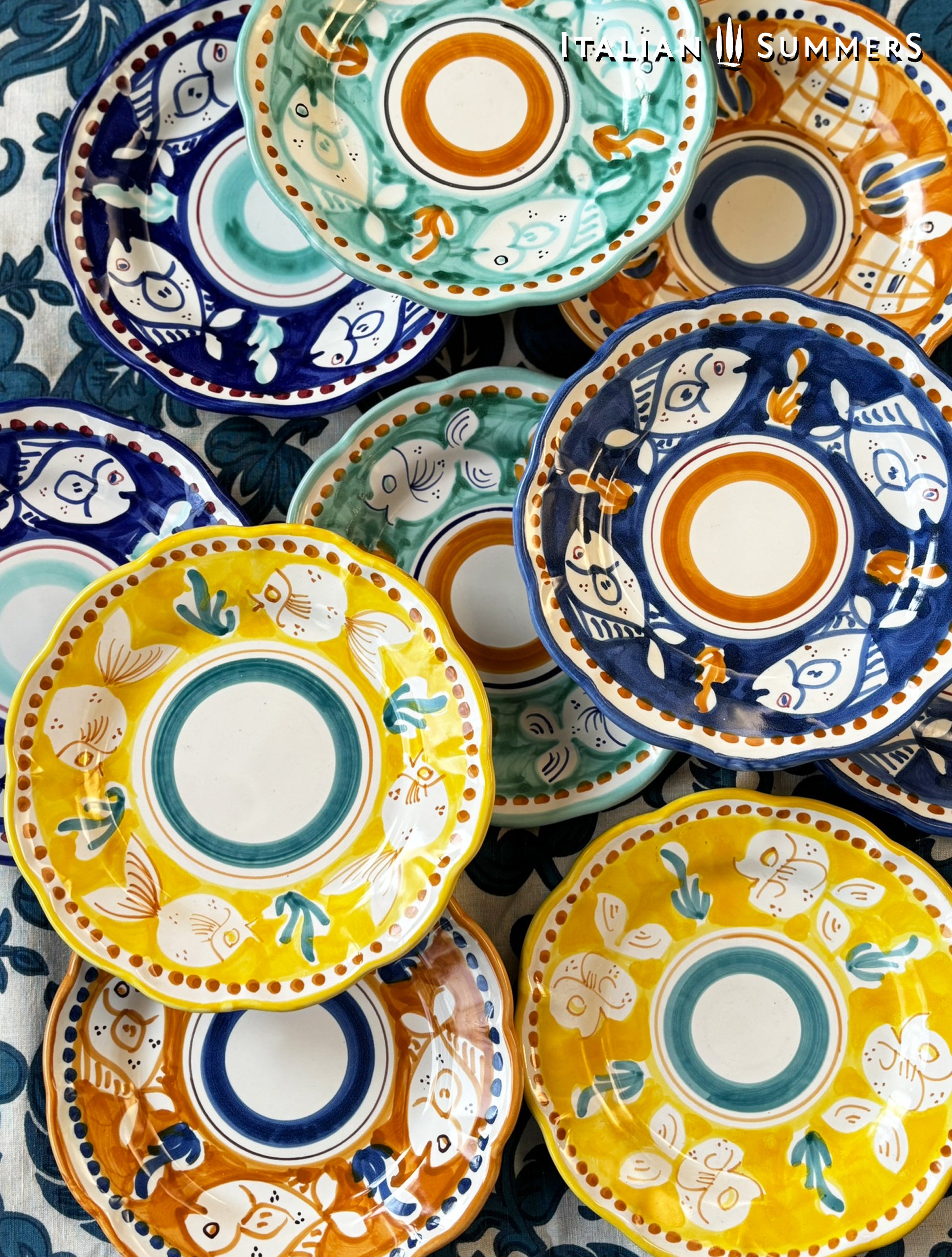  A group of Colorful hand-painted Vietri Pasta Plates with fish theme decorations from the Amalfi Coast on a blue and white tablecloth