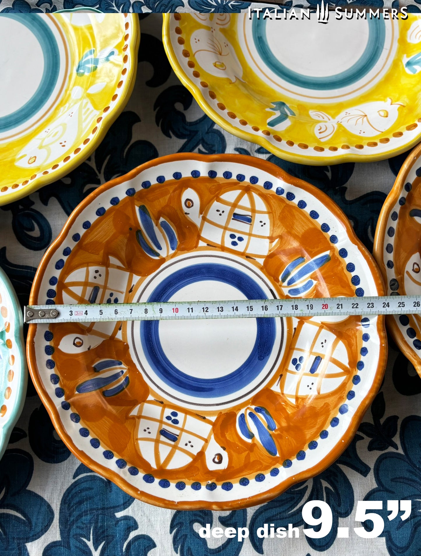  A close-up of Colorful hand-painted Vietri Pasta Plates with fish theme decorations from the Amalfi Coast on a blue and white tablecloth

