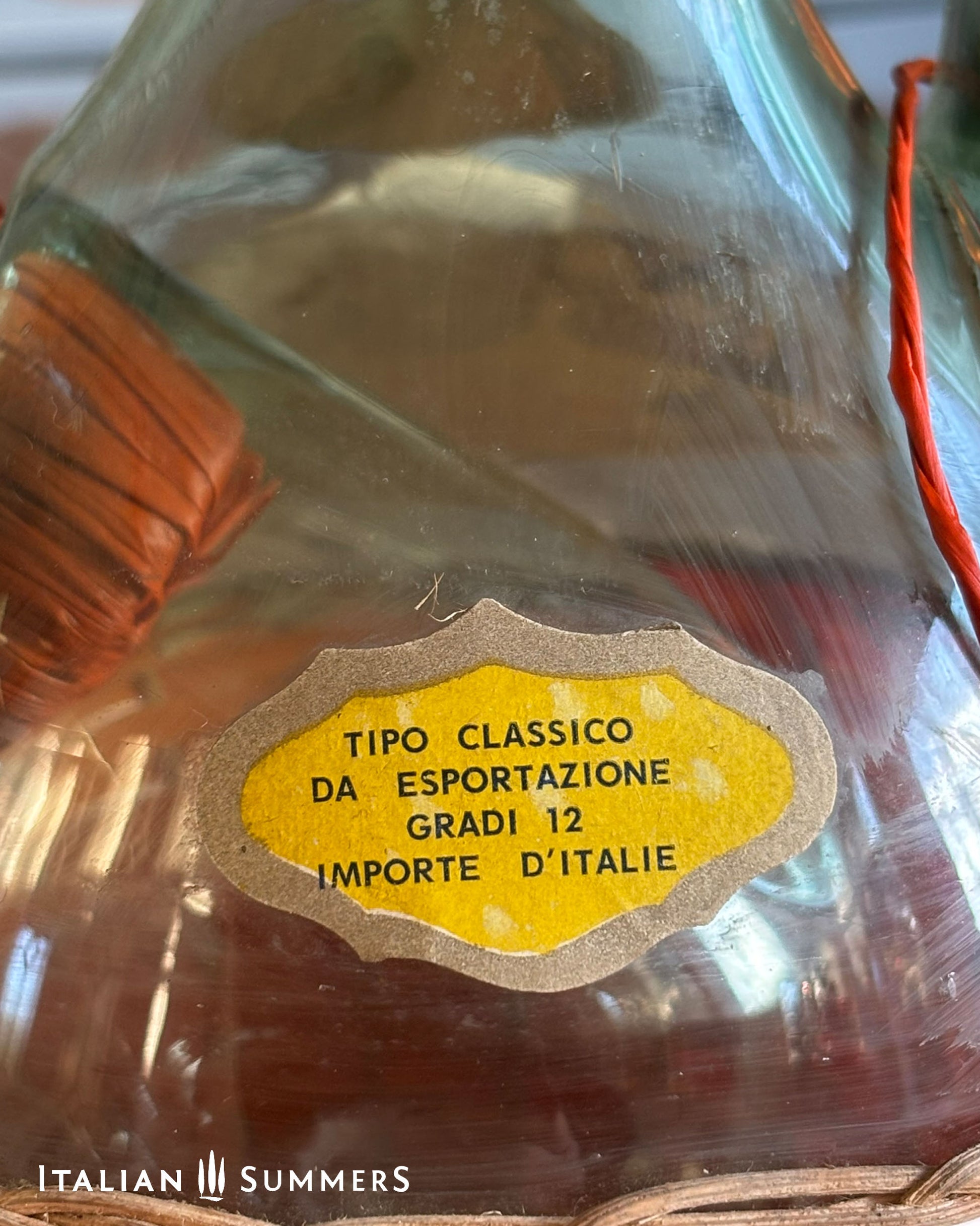 Glass bottle with a close-up of a yellow label and 'Italian Summers' branding.