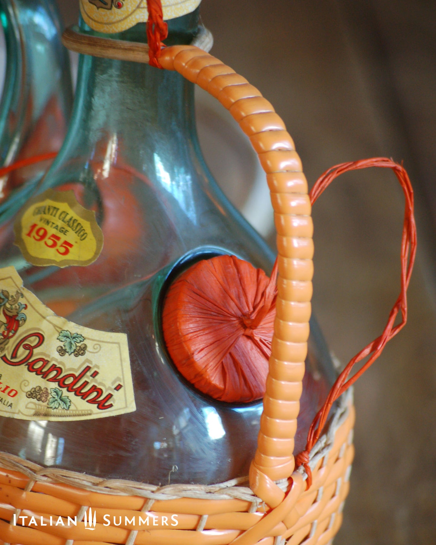 Vintage 1955 Chianti Bandini bottle with decorative elements in a wicker basket