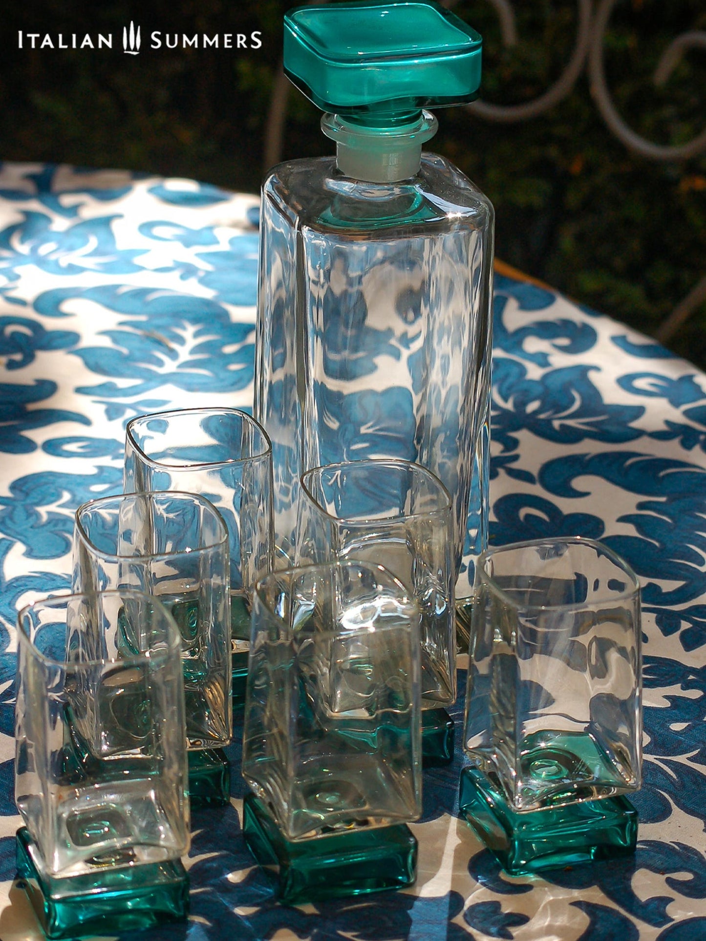 Vintage Bormioli Monet glass set from Italy, featuring square whiskey glasses with bold green foot and matching decanter, displayed on a table in retro style.