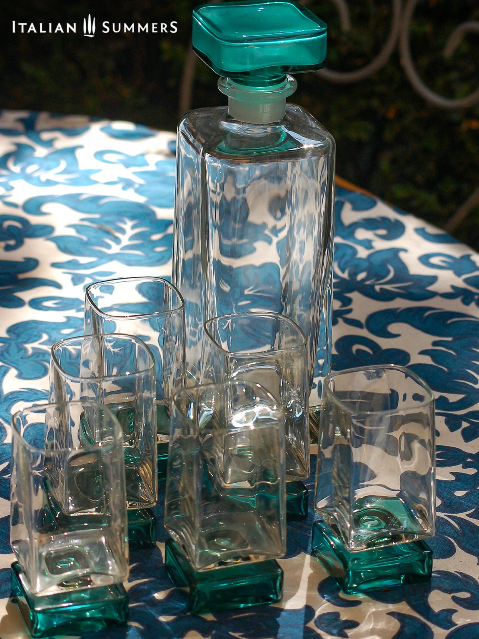 Vintage Bormioli Monet glass set from Italy, featuring square whiskey glasses with bold green foot and matching decanter, displayed on a table in retro style.