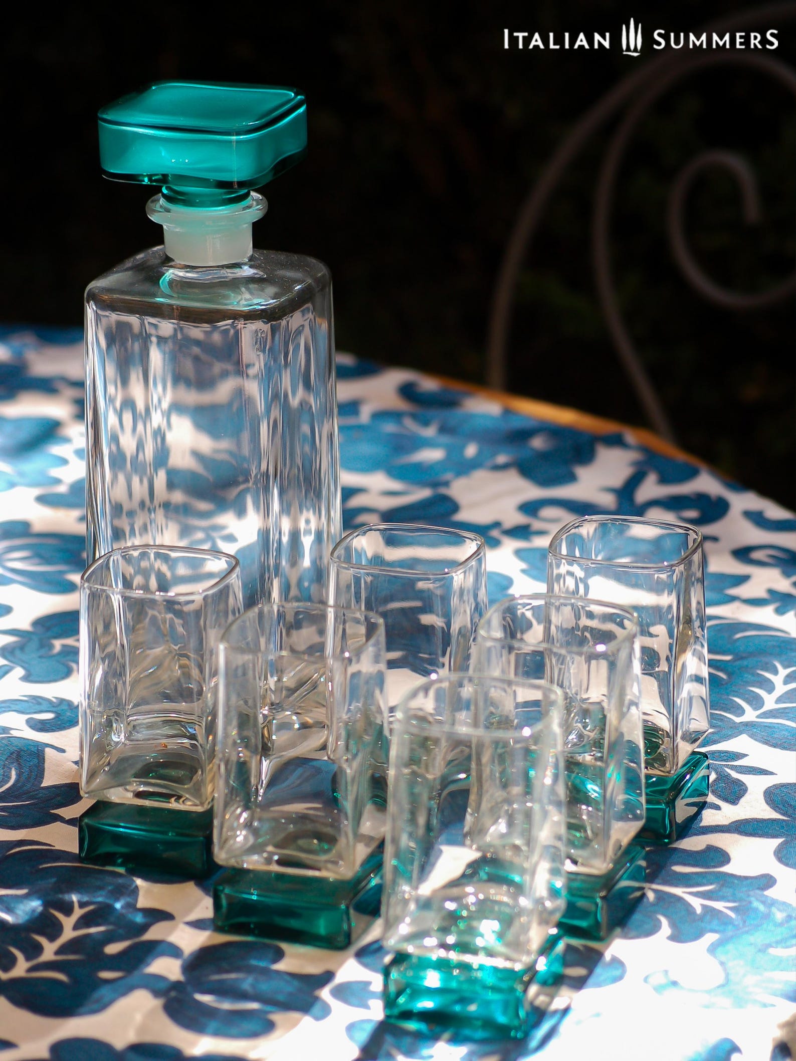 Vintage Bormioli Monet glass set from Italy, featuring square whiskey glasses with bold green foot and matching decanter, displayed on a table in retro style.
