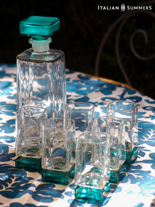 Vintage Bormioli Monet glass set from Italy, featuring square whiskey glasses with bold green foot and matching decanter, displayed on a table in retro style.