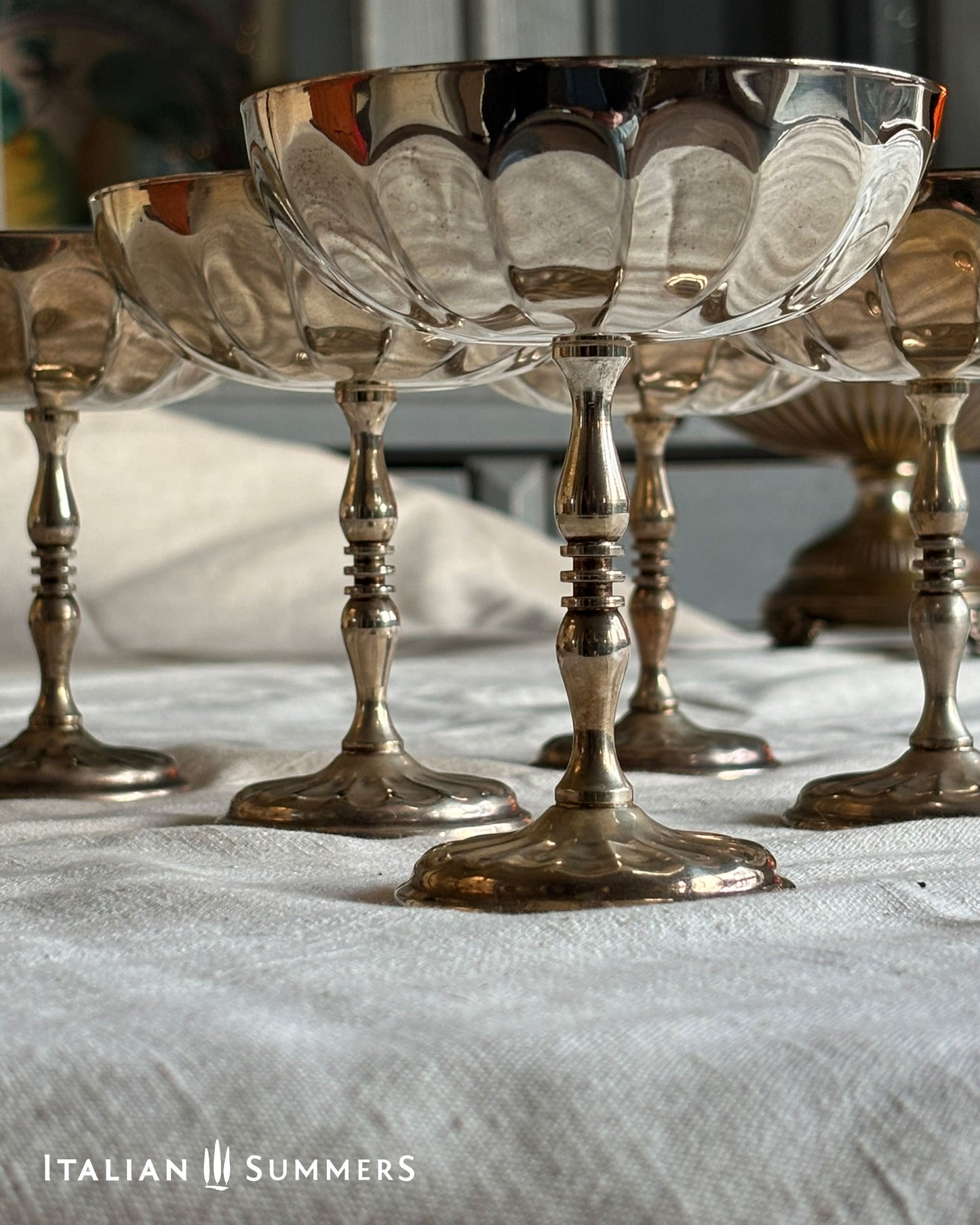 Silver goblets on a white cloth with 'Italian Summers' branding.
