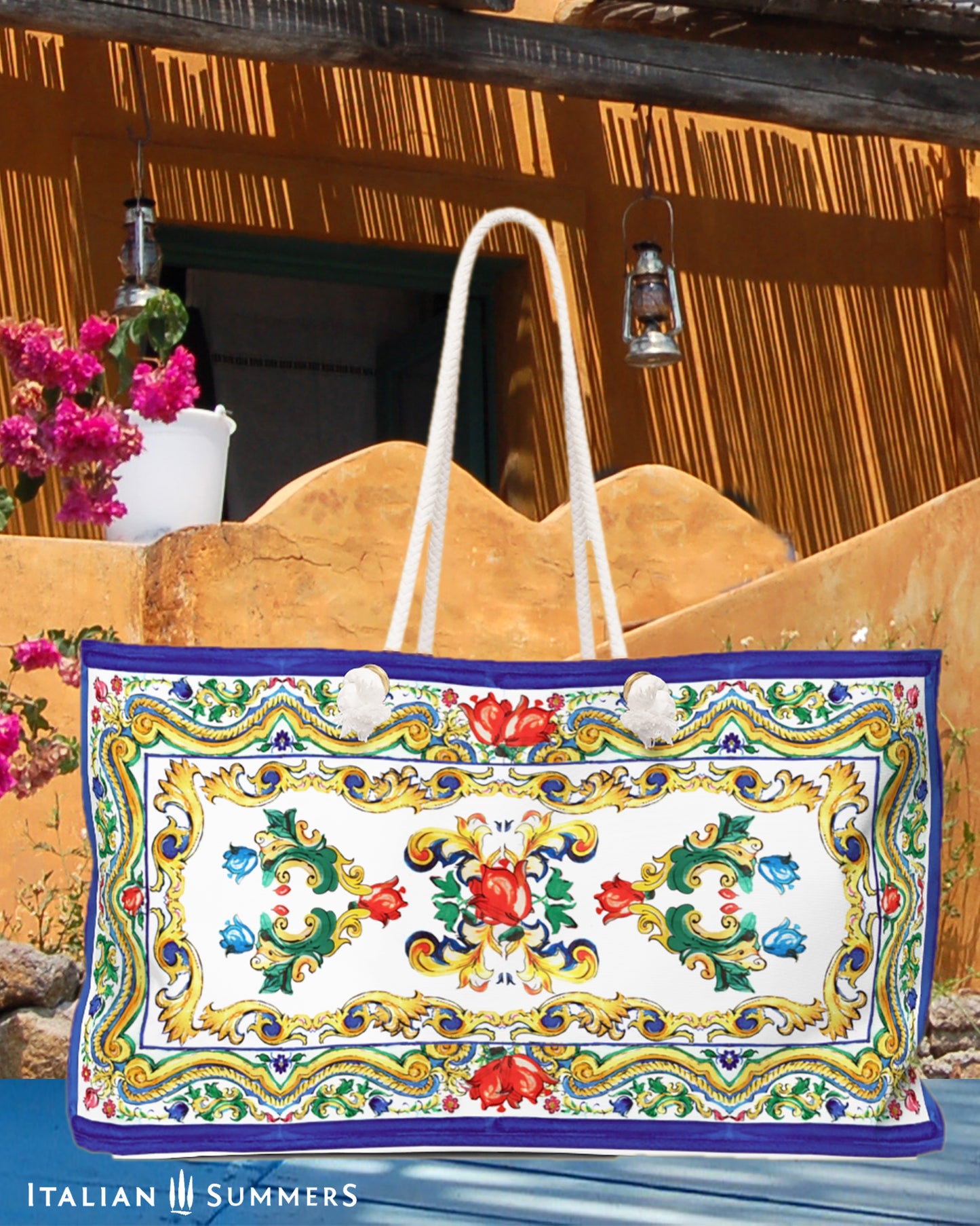 Italy beach bag inspired Sicilian baroque convolutes, Sicilian tiles and flowers. on the tim and bottom of the bag is a blue border. Main colors of the flowes/tiles are blue, red and green. The beach bag has soft rope handles. Designed by Italian Summers.