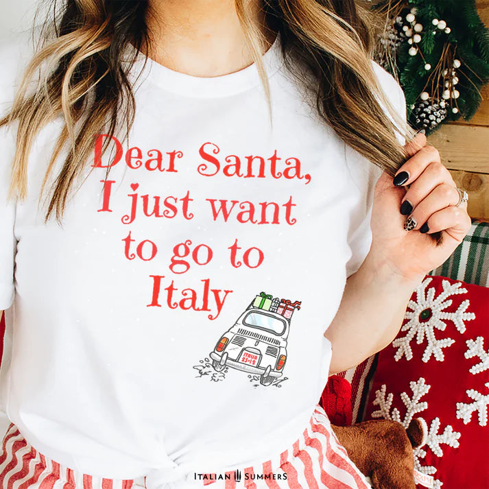 Italy Christmas white
 T shirt featuring a cute vintage Fiat car loaded with gifts and driving away in the snow. A large text states: " Dear Santa  I just want to go to Italy"