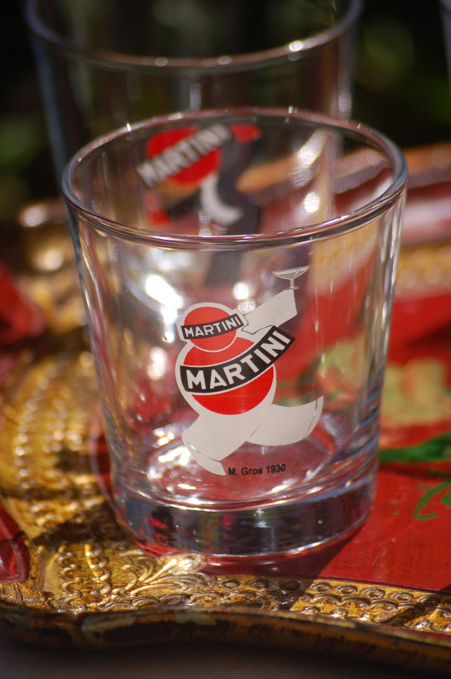 Clear glass with Martini logo on a decorative tray
