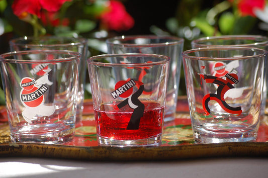 Set of Martini-themed  glasses on a tray with a blurred floral background