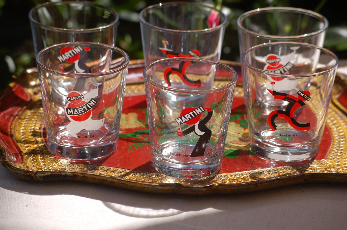 Set of six Martini  glasses on a decorative tray with a red and gold design.