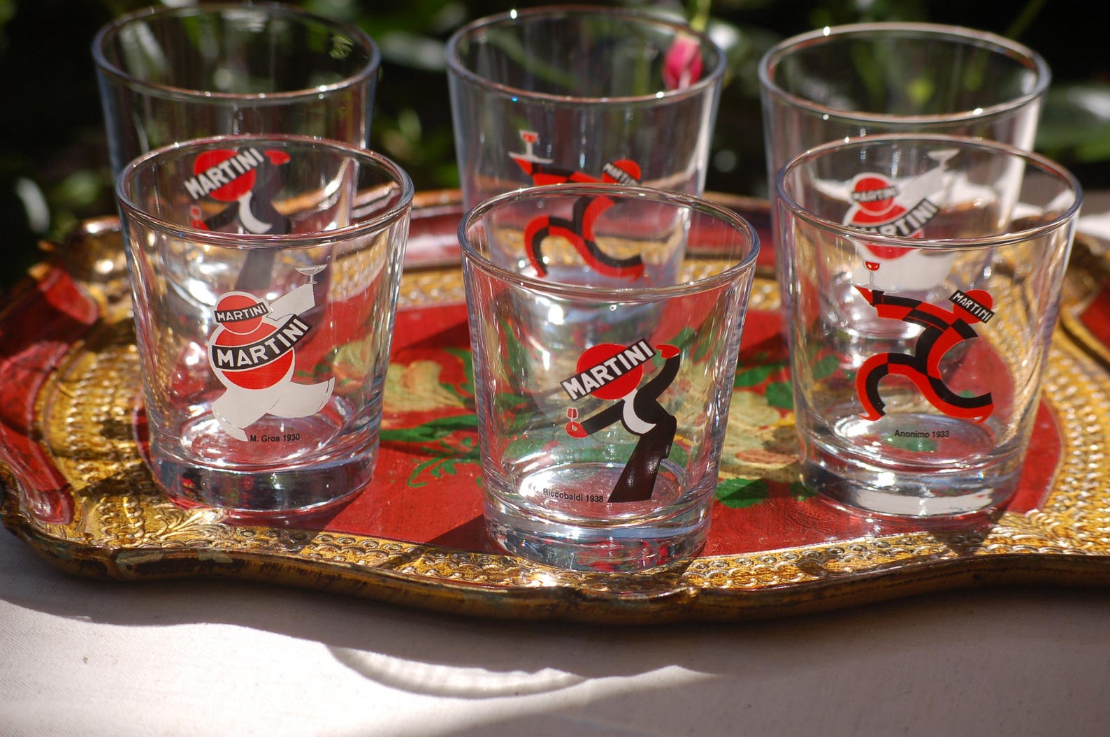 Set of six Martini  glasses on a decorative tray with a red and gold design.