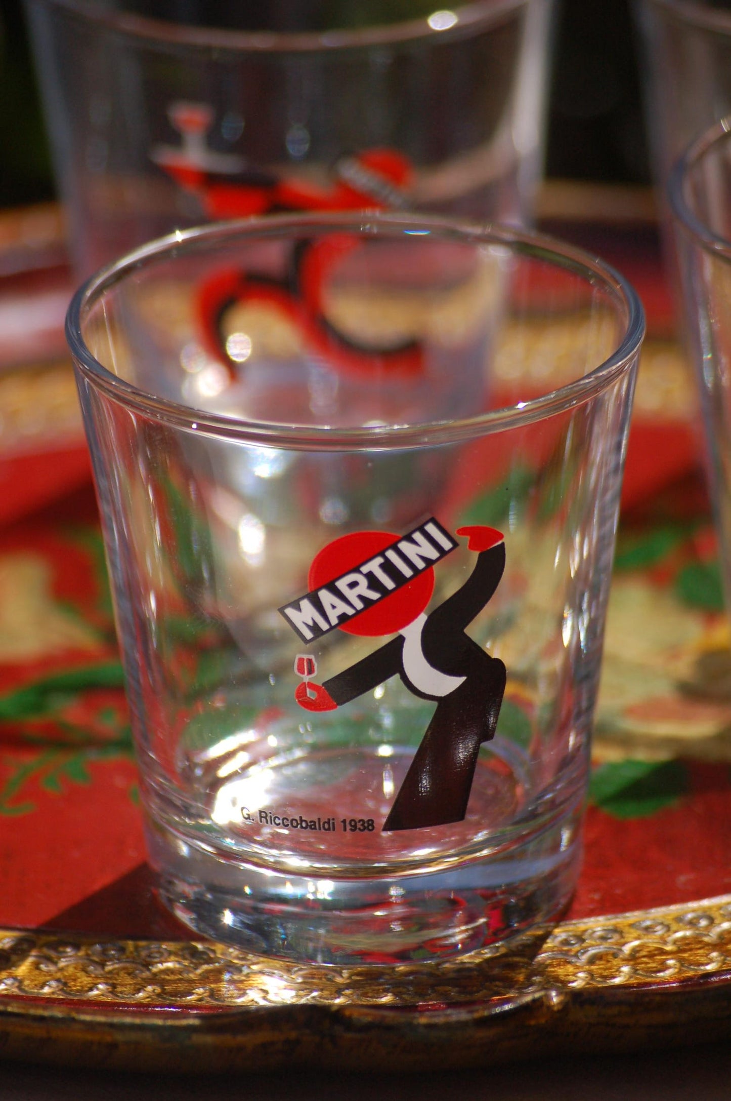 Clear glass with Martini logo on a decorative tray