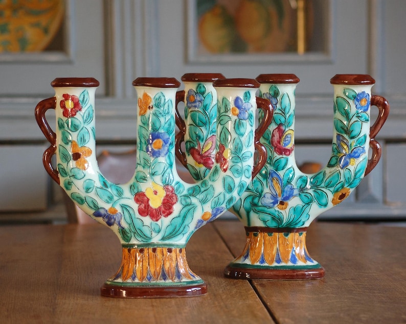 Colorful ceramic candleholders by Cerart Monaco  with floral design on a wooden surface