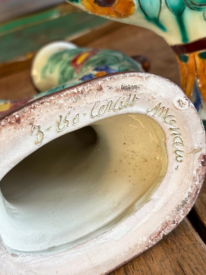 Close-up of a ceramic product with ' Monaco' - Cerart text on a wooden surface