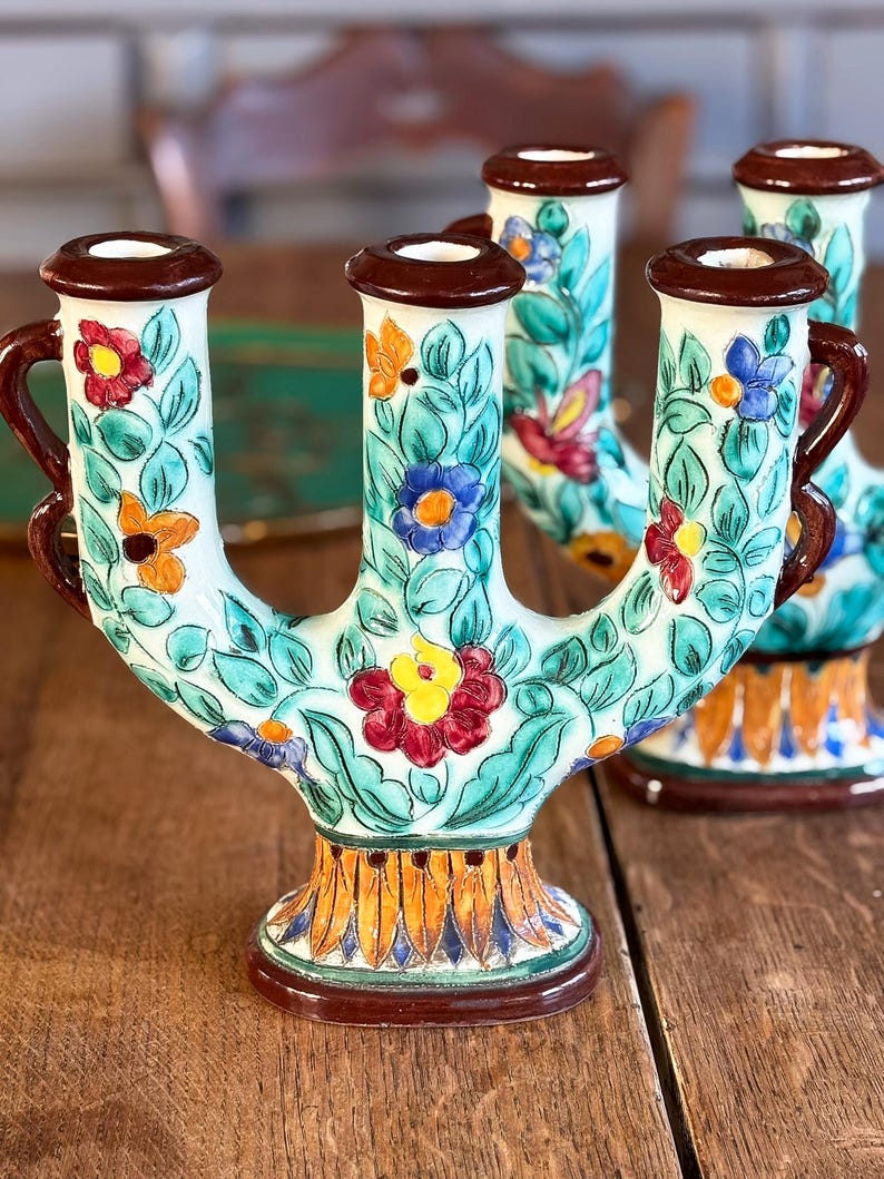 Decorative ceramic candleholders by  Cerart with floral patterns on a wooden surface