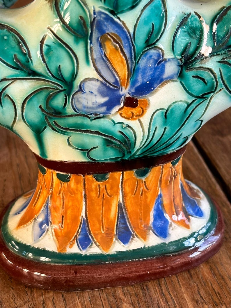 Ceramic candleholder with floral design on a wooden surface