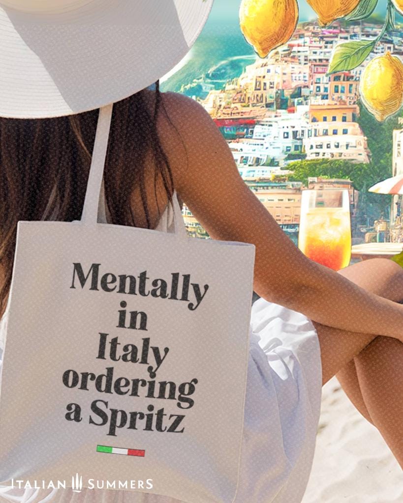 Italy canvas tote bag with the text Mentally in Italy ordering a Spritz. Under the text you see a little bar with the happy colors of the Italian flag. The text of the quote is in black. Designed by Italian Summers