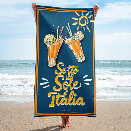 Vintage navy blue beach towel with the text “Sotto il Sole d’Italia,” a sketch of two spritz glasses, and a stylized sun, evoking the feeling of an Italian summer under the Mediterranean sun by Italian Summers
