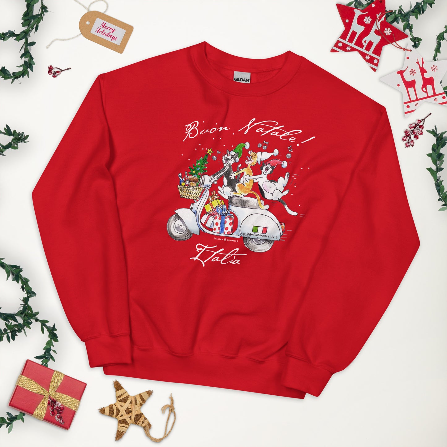 A red Italy-inspired sweatshirt features a large front print of three Italian cats speeding on a vintage Vespa scooter with a load of presents and a asketful of Italian goodies. The cats are singing and the last cat has to hold on as the scooter zooms by. A "Buon Natale" text is printed on top.