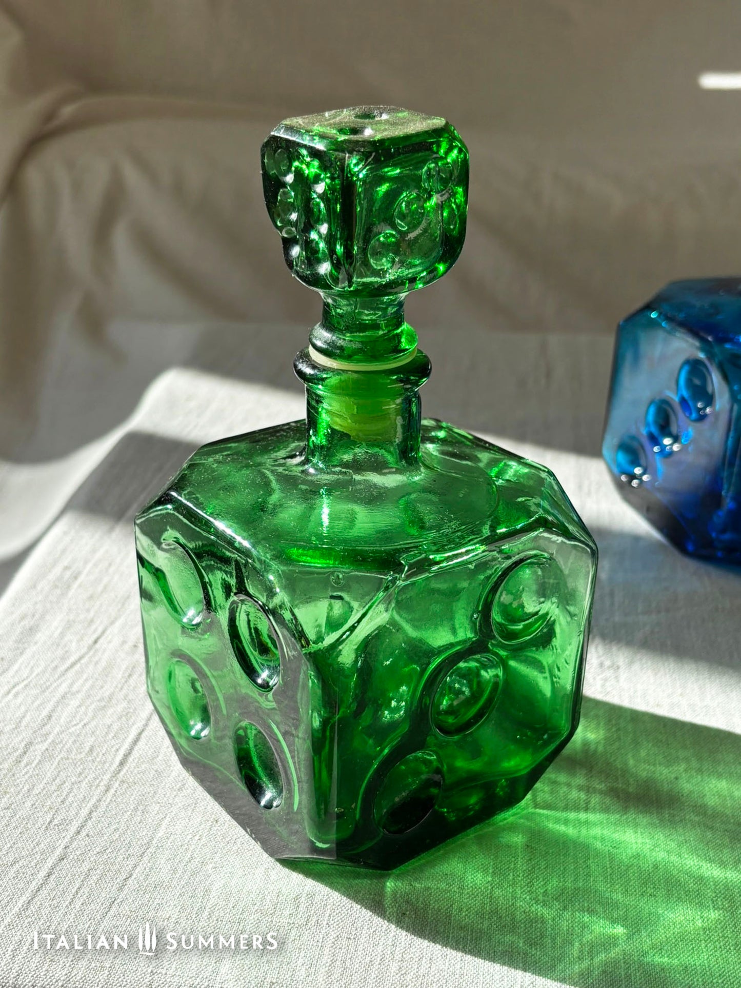 Emerald Green Empoli dice glass decanter on a light background