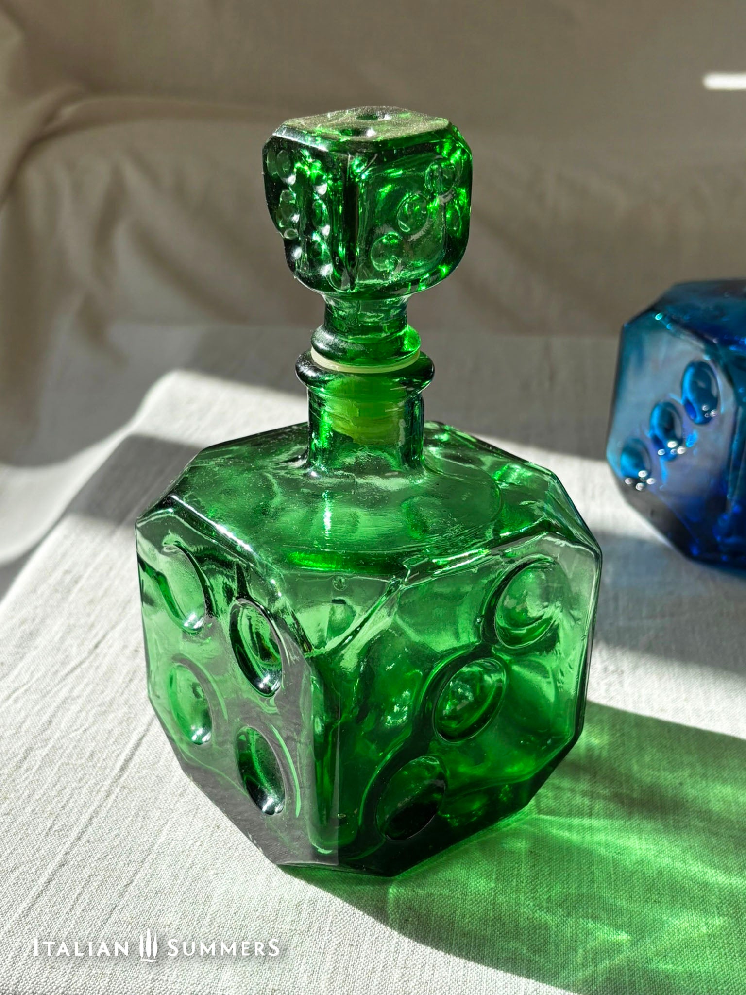Emerald Green Empoli dice glass decanter on a light background